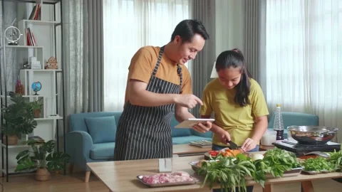 Asian Father Using Tablet And Teach His Daughter How To Cook At Home Stock Footage 160551248