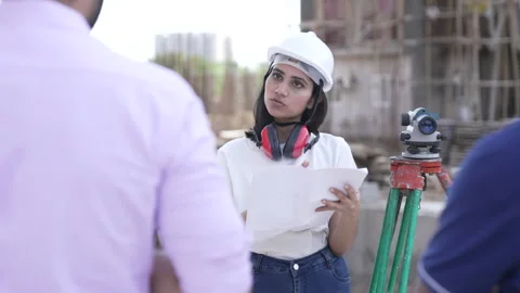 Asian female architect using papers to discuss with team while work on site. 動画素材 161809202