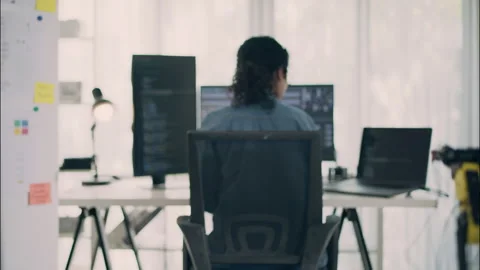 Asian Female Coder Working with Multiple Screens in Modern Workspace. Stock Footage 307587295
