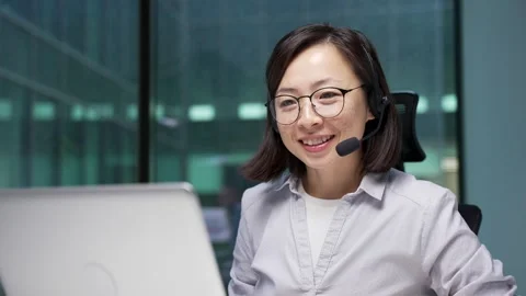 Asian female corporate operator in headset working in customer support service  Stock Footage 315464414