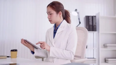 Asian female doctor scientist using digital tablet reading medical data res.. Stock Footage 335643448