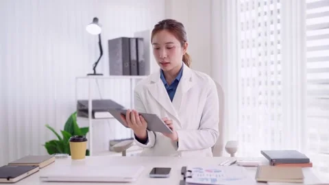 Asian female doctor using tablet computer digital technology reviewing medi.. Stock Footage 335643584