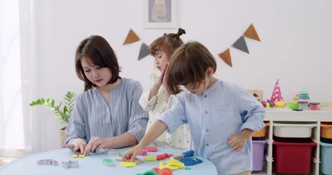 Asian female educator demonstrates clapping game, toddler girl imitates, toddler Stock Footage 329545345