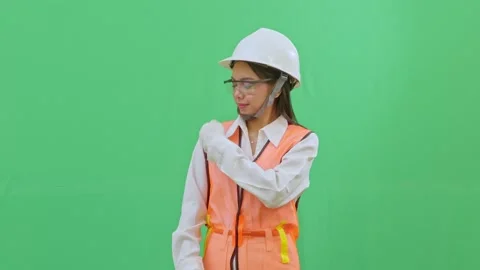 Asian Female Engineer Dusting Off Dirt from Safety Vest on Green Screen Stock-Footage 332057169