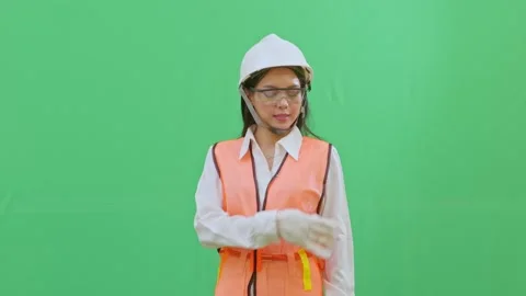 Asian Female Engineer Dusting Off Dirt from Safety Vest on Green Screen Stock-Footage 332057321