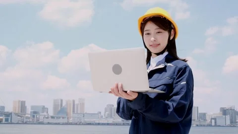 Asian Female Engineer in Hard Hat Working on Laptop Outdoors Stock Footage 344091775