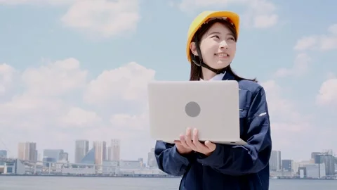 Asian Female Engineer in Hard Hat Holding Laptop and Looking Away Vídeos de archivo 344091809