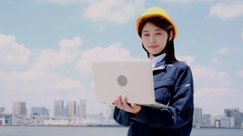 Asian Female Engineer in Hard Hat Using Laptop at Industrial Site Vídeos de archivo 344091816