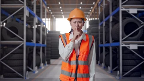 Asian Female Engineer Making Shh Gesture at Tire Warehouse Stock Footage 341788118