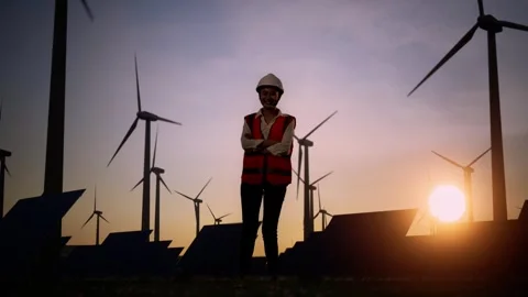 Asian Female Engineer Smiles Posing Arms Crossed In The Wind Turbines Rotating Stock Footage 255857452