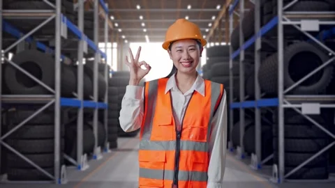 Asian Female Engineer Smiling And Showing Okay Gesture To Camera Tire Warehouse Video stock 341787982