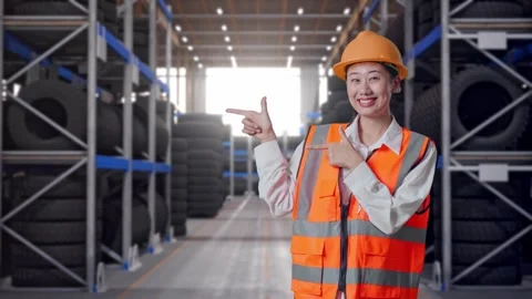 Asian Female Engineer Smiling And Pointing To Side at Tire Warehouse Stock Footage 341788074