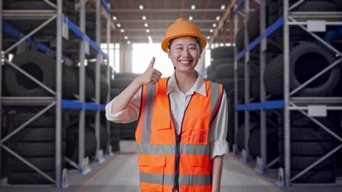 Asian Female Engineer Smiling And Showing Thumbs Up Gesture at Tire Warehouse Stock Footage 341788143