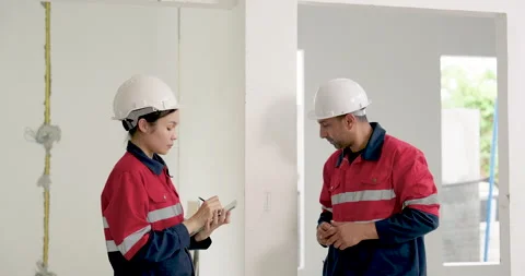 Asian female engineer takes notes while male supervisor points at unfinished 動画素材 337630672