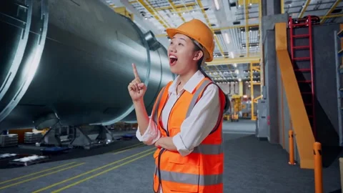 Asian Female Engineer Thinking Then Raising Her Index Finger In Pipe Factory Stock Footage 275034183