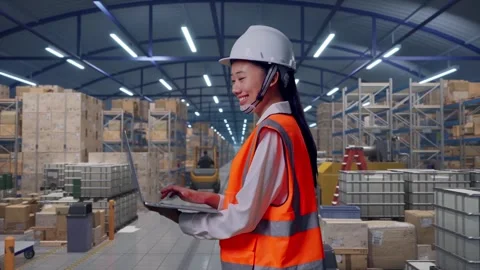 Asian Female Engineer Use Computer While Walking in Warehouse Stock Footage 317546417