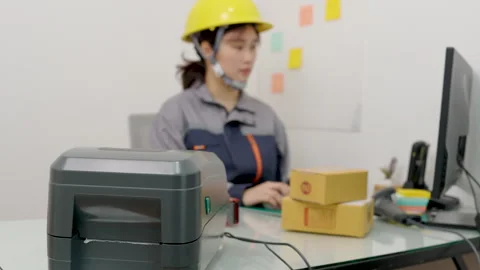 Asian female engineer uses a computer to print barcode stickers Stock Footage 327629506