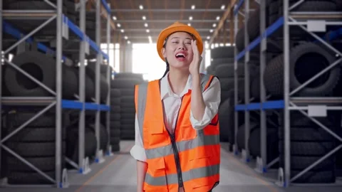 Asian Female Engineer Yelling With Hand Over Mouth at Tire Warehouse Video stock 341788155