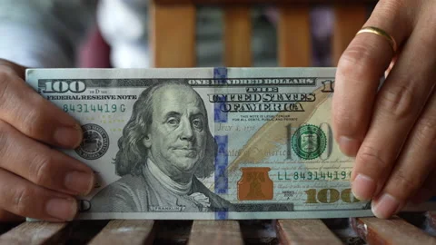 Asian female hands putting a stack of 100 dollar bills on a table Stock Footage 234634868