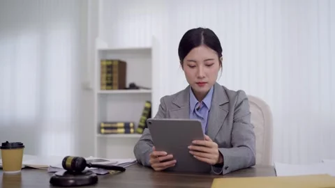 Asian female lawyer using tablet computer reviewing legal document case in .. Video stock 336474749