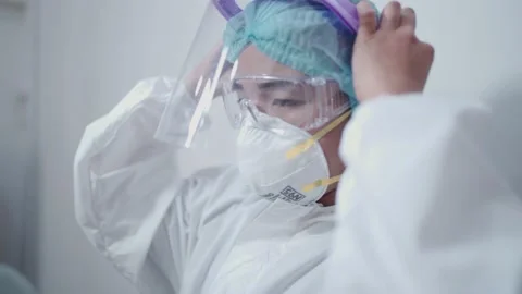 Asian female nurse wearing white ppe suit, medical protective suit Stock Footage