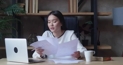 Asian female office manager is sorting through a huge pile of business documents Stock Footage 161150143