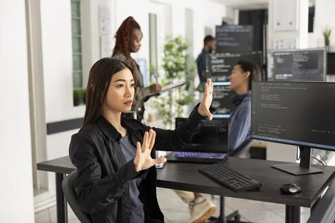 Asian female programmer coding in virtual reality workspace Stock Photos