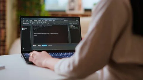 Asian female programmer works on coding software in a home office setup Stock Photos