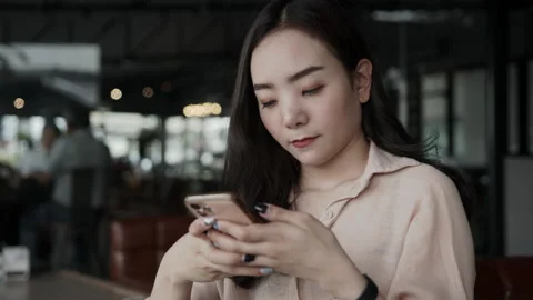 Asian female reading text message or social media on cell telephone during in Stock Footage 149387245