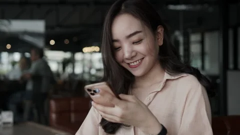 Asian female reading text message or social media on cell telephone during in Stock Footage 149387300