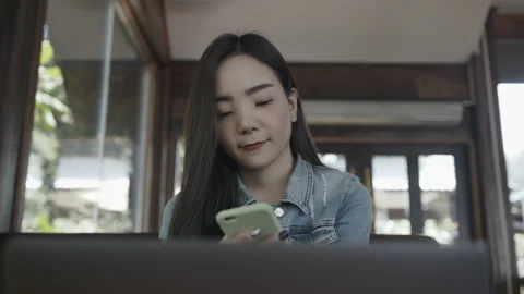 Asian female reading text message or social media on cell telephone during in Stock Footage 149387505