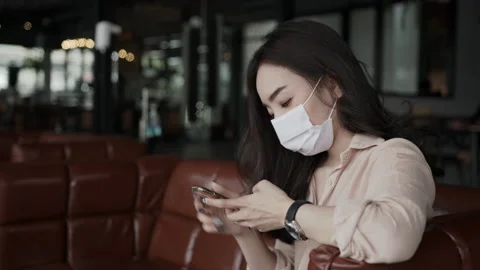 Asian female reading text message or social media on cell telephone during in Stock Footage 149953662