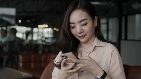 Asian female reading text message or social media on cell telephone during in Stock Footage 150296023