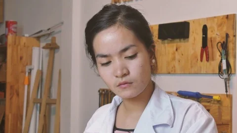 Asian female scientist with maker tools behind her in a makerlab Stock Footage