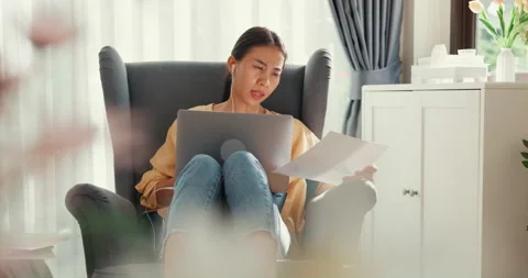 Asian female sit on sofa with computer laptop wear earphone online meeting. Stock Footage 202154305
