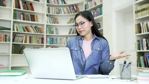 Asian female student having learning difficulties using laptop taking notes  Stock Footage 274142745