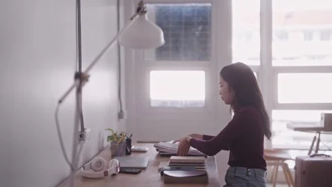 An Asian female student is in the process of organizing her belongings as s.. Stock Footage 254529690