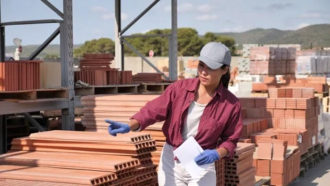 Asian female taskmaster in uniform with document in hand calling out for someone Stock Footage 315032236