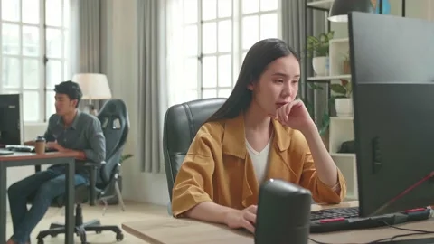 Asian Female Thinking While Works On Her Personal Computer In Office Stock Footage 158094919