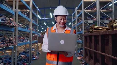 Asian Female Use Computer While Walking at Scrap Warehouse Stock Footage 318077821