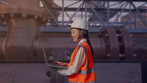 Asian Female Use Computer While Walking with Industrial Pipeline Stock Footage 318078565