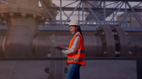 Asian Female Use Computer While Walking with Industrial Pipeline Stock Footage 318078742