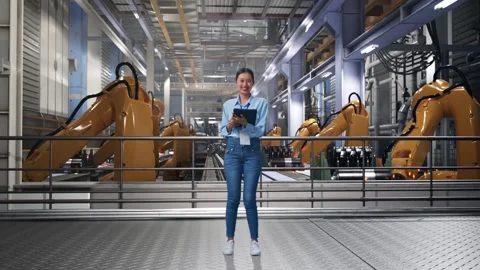 Asian Female Worker Use A Tablet And Smiling To Camera With Robotic Arms Stock Footage 301931797