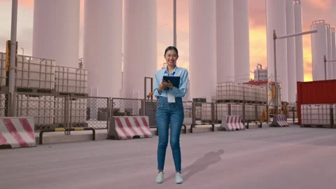 Asian Female Worker Use A Tablet And Smiling To Camera at Storage Facility Stock Footage 337755739