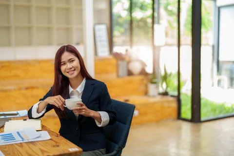 Asian female worker using computer and budget documents on desk Stock Photos