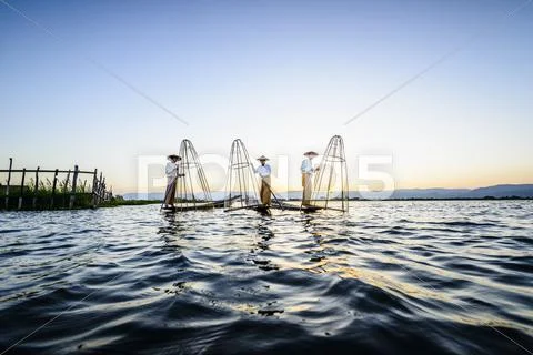 Asian Fishermen Fishing In Canoes On River