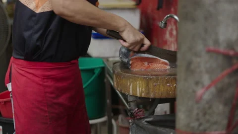 Asian fishmonger cutting a slice of fresh salmon at a market in thailand Stock Footage 221518276