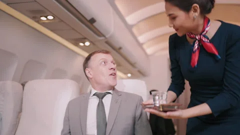 Asian Flight attendants serving drinks, elderly people, male businessmen Stock Footage 150350308