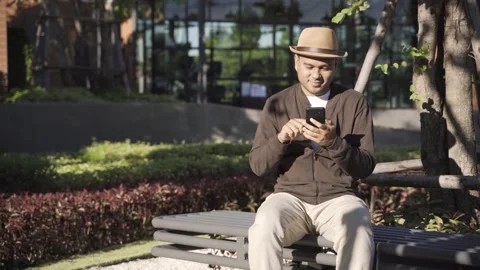 Asian freelancer put on brown hat working outdoor. Office worker or businessman  Stock Footage 144518618