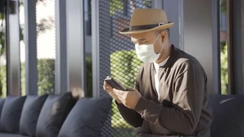 Asian freelancer put on brown hat and face mask working outdoor. Office worker o Stock Footage 144519159